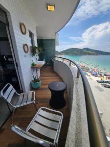 a balcony with chairs and a view of the beach at Suite Memorália Mar 1 in Arraial do Cabo