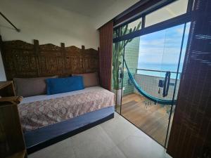 a bedroom with a bed with a view of a balcony at Suite Memorália Mar 1 in Arraial do Cabo