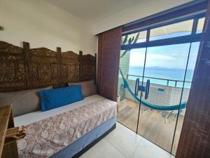 a bedroom with a bed and a view of the ocean at Suite Memorália Mar 1 in Arraial do Cabo +23 photos