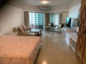 Una habitación de hotel con una cama y una sala de estar. en 20FL Beach Front Huge 1-Bed Condo Next to 5-Star Hotels, en Pattaya central