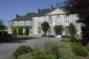 a large house with white windows and a driveway at Chateau de Vouilly in Vouilly