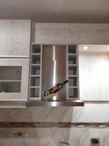 a bottle of wine sitting on top of a kitchen hood at Alojamiento EL DESCANSO in Olavarría +7 photos