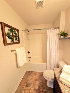 a bathroom with a tub and a toilet and a shower at Prime Location in Chesapeake with Spacious 4BR & Big Kitchen in Chesapeake +37 photos