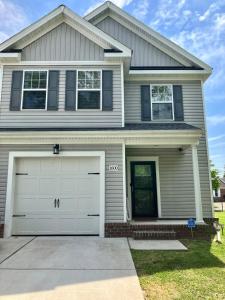 a house with two garage doors in front of it at Prime Location in Chesapeake with Spacious 4BR & Big Kitchen in Chesapeake