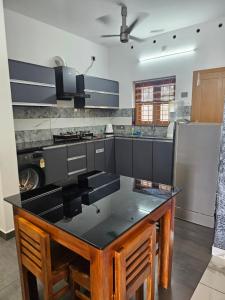 a kitchen with a island in the middle at MetroNova Homes - Furnished stay in Ambalappuzha in Alleppey