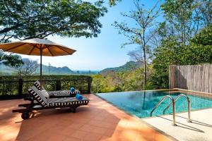 a pool with a chair and an umbrella next to it at SAii Phi Phi Island Village in Phi Phi Islands
