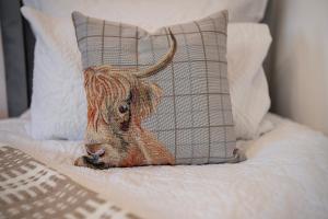 una estatua de una vaca sobre una cama junto a una almohada en The Tarantino - Grampian Lettings, en Aberdeen