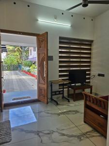 an open door to a room with a desk and a computer at MetroNova Homes - Furnished stay in Ambalappuzha in Alleppey
