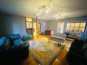 大町市フリーフロー付きB&B Lodge GRAMP的带沙发和地毯的客厅