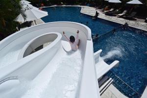 a woman going down a water slide at a pool at Art Hotel Ishigakijima in Ishigaki Island