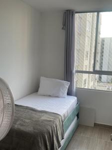 ein Bett in einem Zimmer mit einem großen Fenster in der Unterkunft Lujoso apartamento in Cartagena de Indias + 5 Fotos