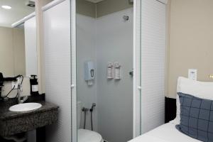 a bathroom with a shower and a toilet and a sink at Hotel Aero Sleep Campinas in Campinas