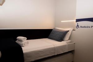 a small bedroom with a bed with a black headboard at Hotel Aero Sleep Campinas in Campinas