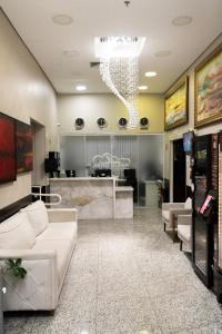 a lobby with a white couch and a table at Hotel Aero Sleep Campinas in Campinas