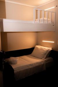 a bedroom with a bed with two bunk beds at Hotel Aero Sleep Campinas in Campinas