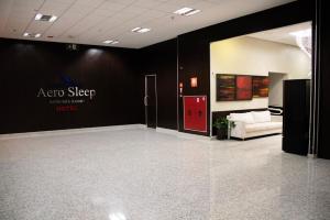 a room with a sign on the wall and a couch at Hotel Aero Sleep Campinas in Campinas