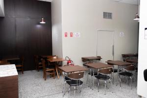a classroom with tables and chairs and a chalkboard at Hotel Aero Sleep Campinas in Campinas