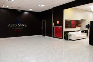 a room with a red door and a white couch at Hotel Aero Sleep Campinas in Campinas