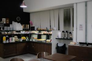 a restaurant with a counter with food on it at Hotel Aero Sleep Campinas in Campinas