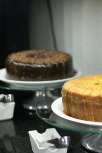 two cakes are sitting on plates on a table at Hotel Aero Sleep Campinas in Campinas