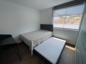 a small room with a bed and a window at Casa de campo en condo cerca a playa Puerto Viejo in San Antonio +42 photos