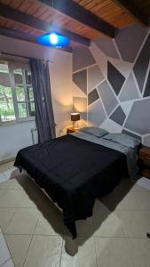 een slaapkamer met een groot zwart bed in een kamer bij Mishki Wasi - Dulce Hogar Magdalena in Magdalena