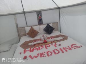 a bed in a tent with red decorations on it at La Danu Glamping in Kubupenlokan