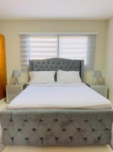 1 cama grande en un dormitorio con 2 mesitas de noche en Excelente Apartamento Completo Renta Carro Disponible, en La Viva