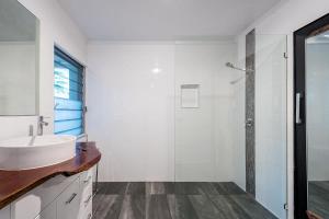 a white bathroom with a sink and a shower at Driftwood By Khove in Gold Coast