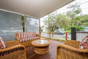 a porch with wicker chairs and a coffee table at Driftwood By Khove in Gold Coast