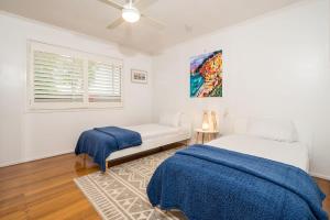 a bedroom with a bed and a couch and a window at Driftwood By Khove in Gold Coast +15 photos