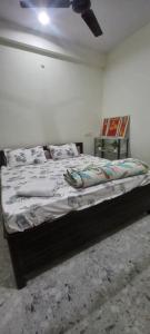 a bedroom with a bed and a ceiling fan at Budget Stay for Family with Atulyam in Prayagraj