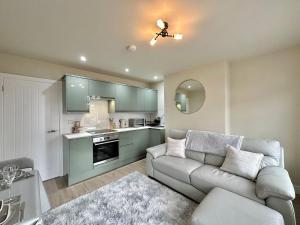 ヘレフォードにあるContemporary City Centre Apartments with Gardenのソファとキッチンのあるリビングルーム