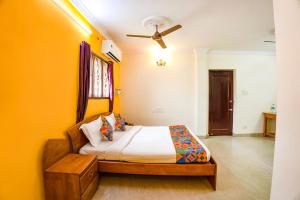 a bedroom with a bed and a ceiling fan at FabExpress Home Tree Service Apartment T Nagar - Near Mambalam Railway Station in Chennai