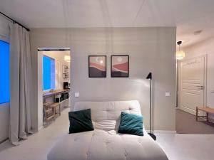 a living room with a white couch and a kitchen at Cozy Studio next to Metro & Mall in Espoo
