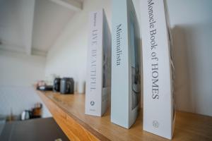 two books sitting on a wooden shelf at Jiva Loft Style Villa in Canggu