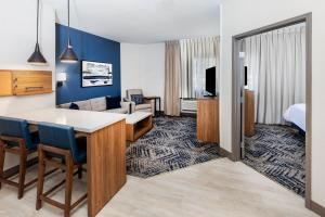 a hotel room with a kitchen and a living room at Candlewood Suites Fayetteville by IHG in Fayetteville