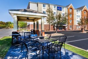 a gazebo with tables and chairs in front of a building at Candlewood Suites Fayetteville by IHG in Fayetteville