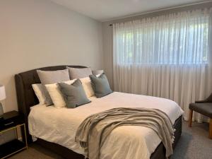 una camera da letto con un letto con cuscini e una finestra di Banksia - Great for 2 families, linen included a Venus Bay