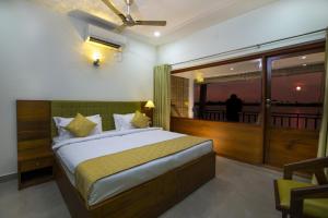 a bedroom with a large bed and a balcony at Mira's PMC Lakeshore Resort in Alleppey