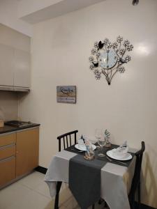 a table in a kitchen with a clock on the wall at Stylish New Studio at McKinley Hill BGC Free Netflix in Manila
