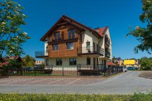 a large wooden house with a balcony at Apartamenty Willa Ada in Jastarnia