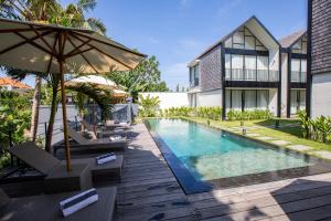 an external view of a villa with a swimming pool at 20 Suites Umalas in Canggu