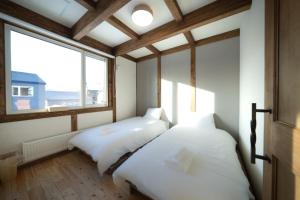 two beds in a room with a window at Oreo Niseko 新築 ニセコ中心地 駐車場2台完備 in Kutchan
