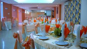 una sala banchetti con tavoli bianchi e sedie bianche di Hotel Turist a Neptun