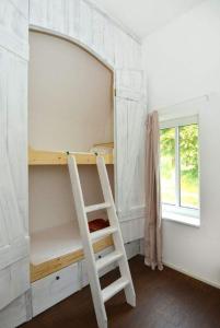 ein Etagenbett mit einer Leiter in einem Zimmer in der Unterkunft Reet-Cottage Nahe der Ostsee in Süsel