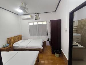 a small room with two beds and a window at Chalern Guesthouse in Luang Prabang