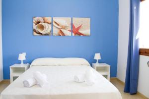 a blue bedroom with a bed with towels on it at Apartamentos Blue Beach by Escape Home in Cala en Forcat