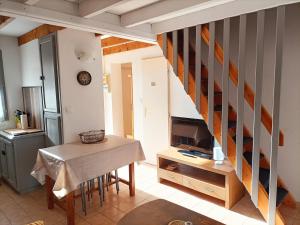 a living room with a table and a staircase at Chez Yamina in Gruissan