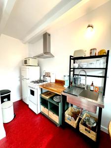 a kitchen with a white stove and a red floor at Charismatic Downtown Solvang Pet-Friendly Studio in Solvang
